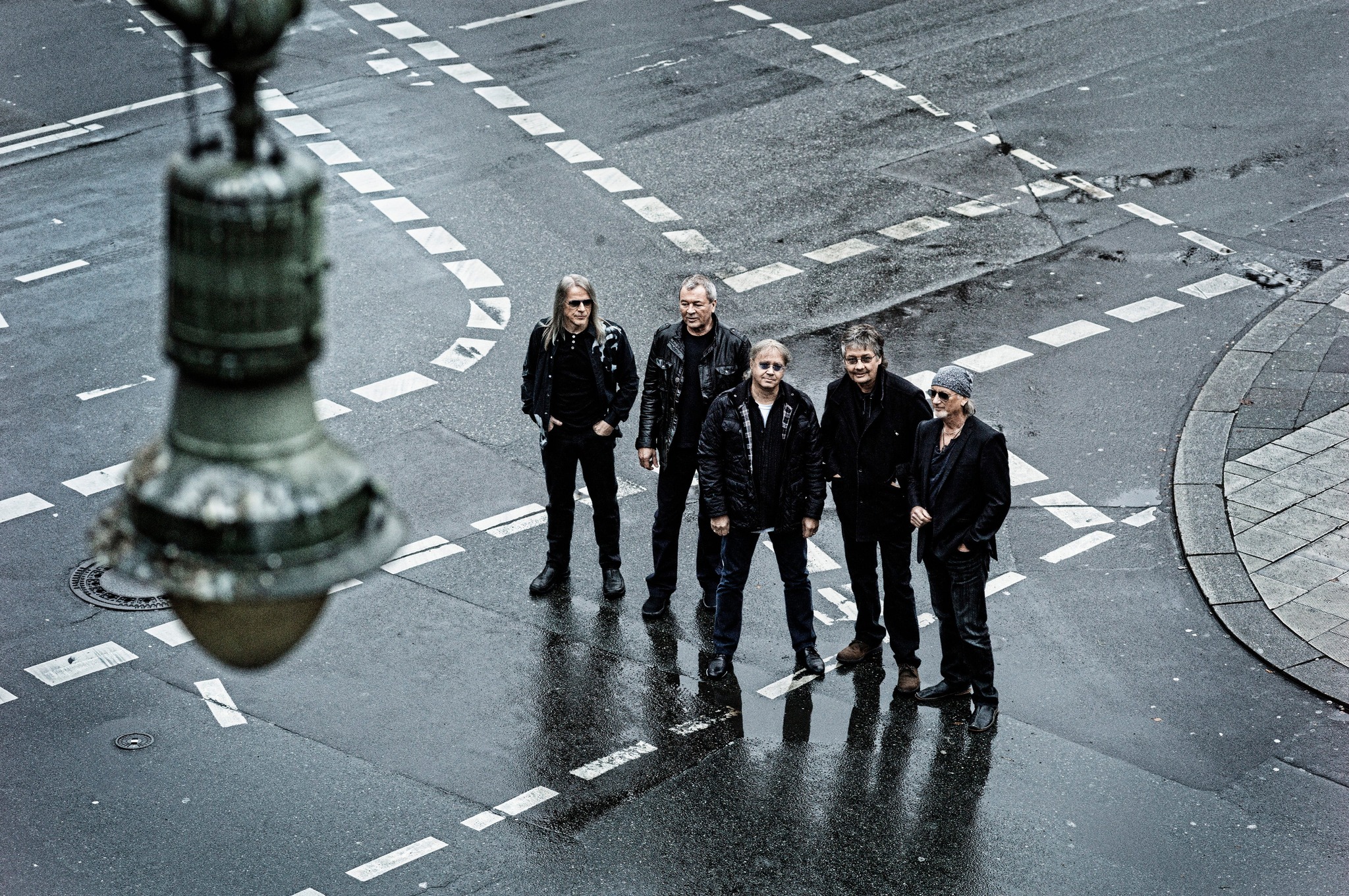 image of 5 people wearing all black standing in empty street